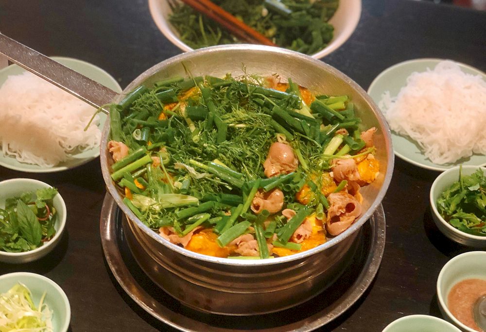 Cha Ca La Vong is renowned for its century-old recipe of turmeric-marinated fish cooked with fresh herbs (Source: Canva)